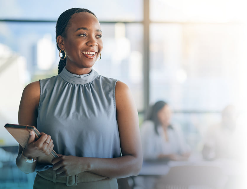 Woman smiling while holding a tablet. A Leadership Challenge Certified Practitioner badge is in the bottom left corner.