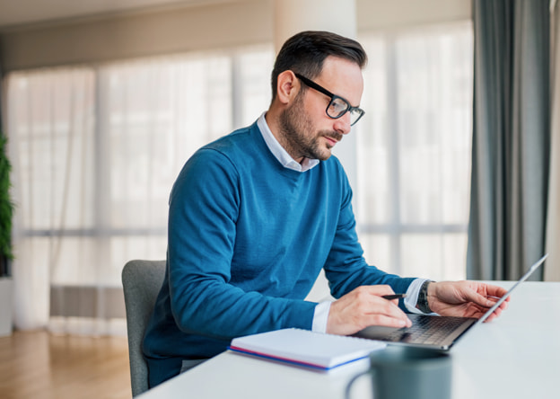 Man working at a laptop taking the LPI Self assessment.