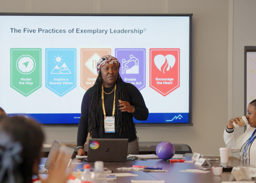 Woman leading a meeting presenting The Five Practices of Exemplary Leadership.
